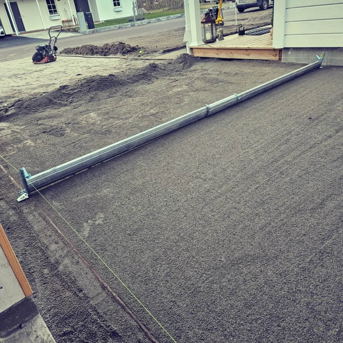Förberedd grund för plattläggning vid husfasad