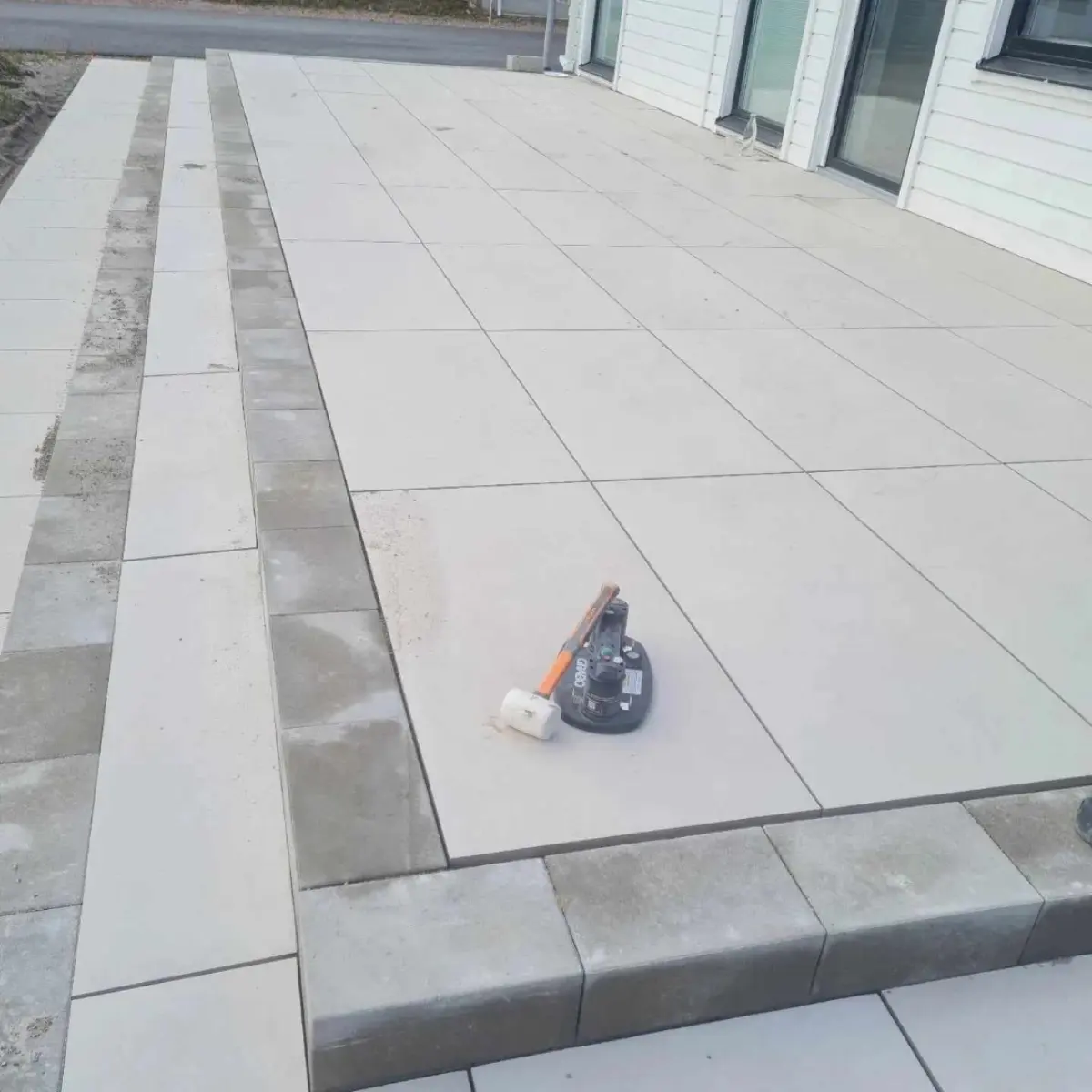 Ljusgrå stenplattor i vinkel vid uppfart
